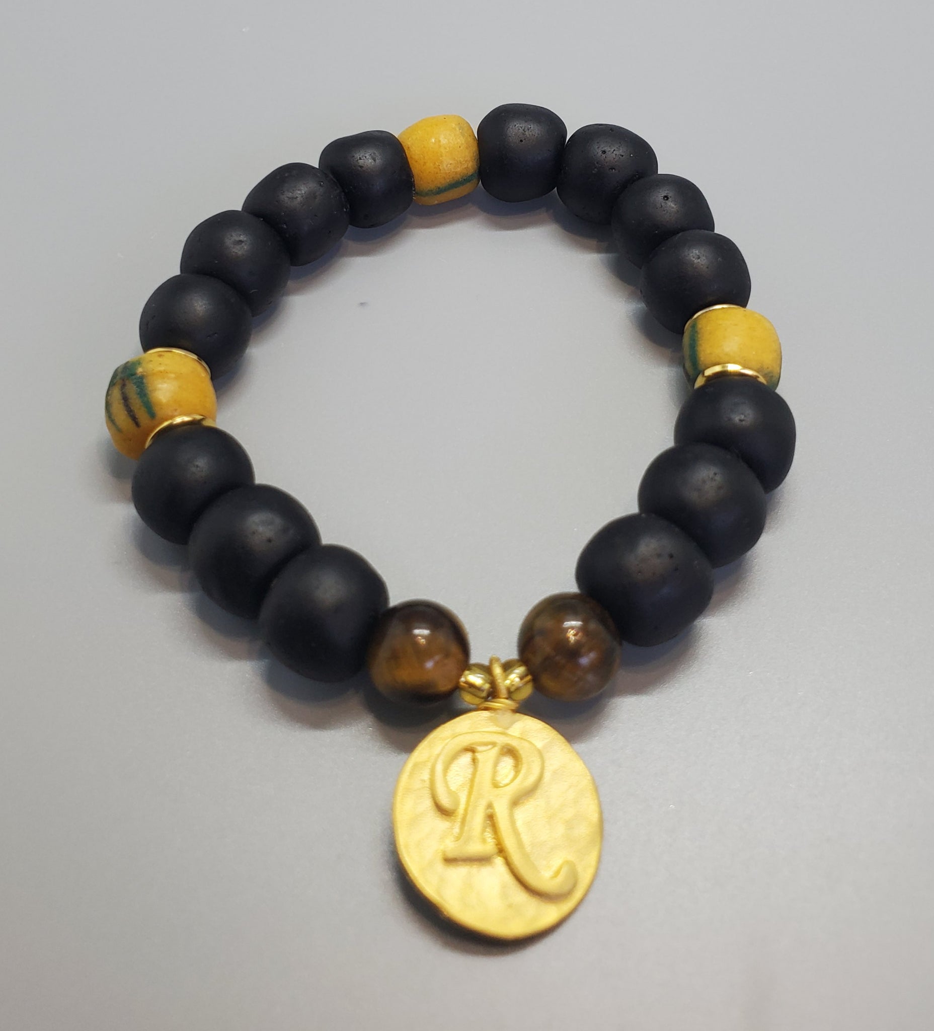 Black, Must. Krobo Beads, Tiger Eye, 22K Gold Plated Plated Brass "R" Charm, Brass, Unisex Stretch Bracelet